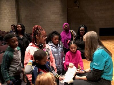 Elementary school students listening to a science academy worker