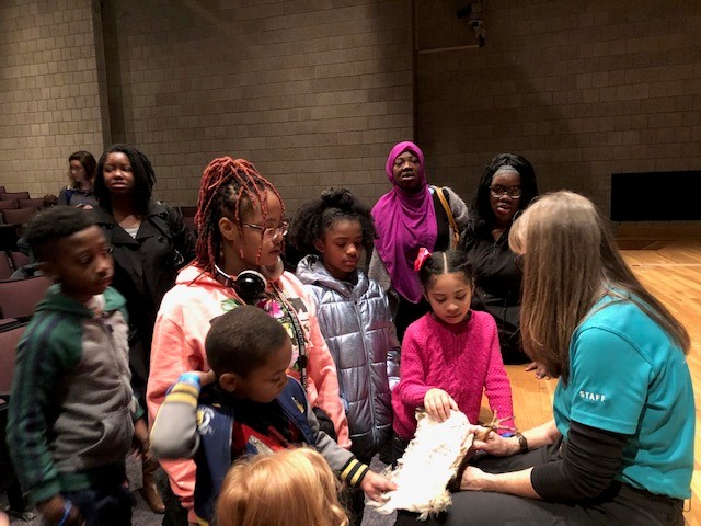 Elementary school students listening to a science academy worker